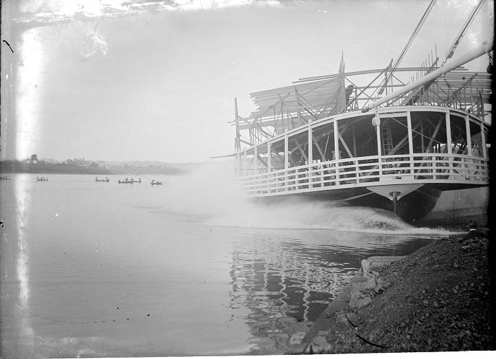 Original black-and-white sidewheel steamboat launching scene